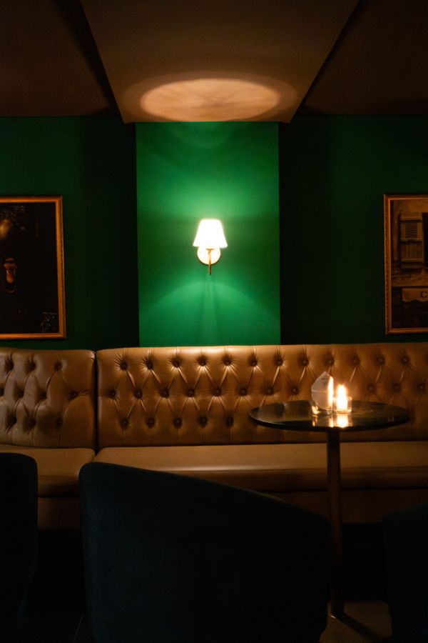 Lounge do Coxixo com sofá capitonê e luz âmbar