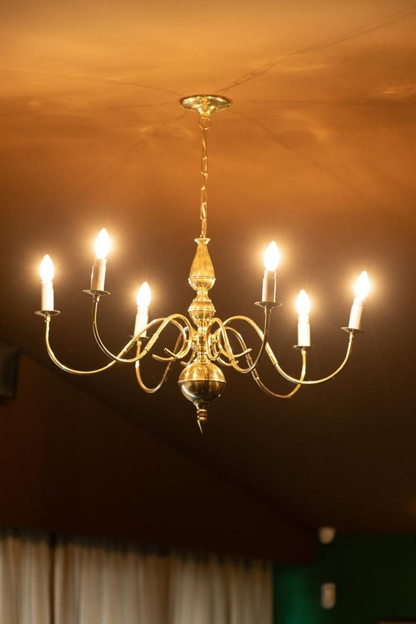 Lustre de bronze aceso sobre o salão do Coxixo
