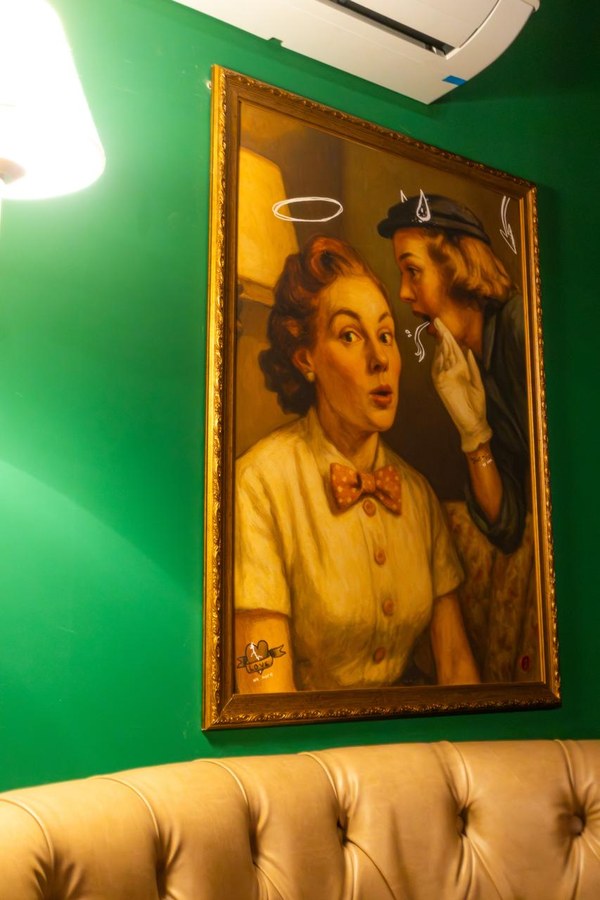 Quadro no salão do Coxixo com uma mulher sussurrando um segredo no ouvido de outra